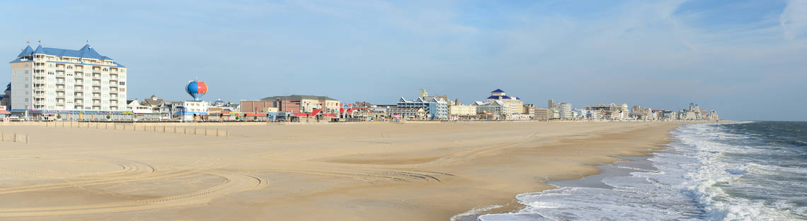 Panoramic view of the deserted Ocean City beach on an early morning on a clear, sunny day