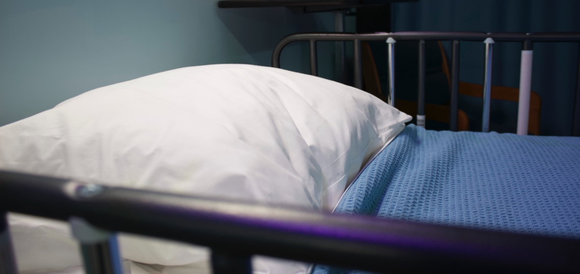 Close up of a hospital bed with blue sheets