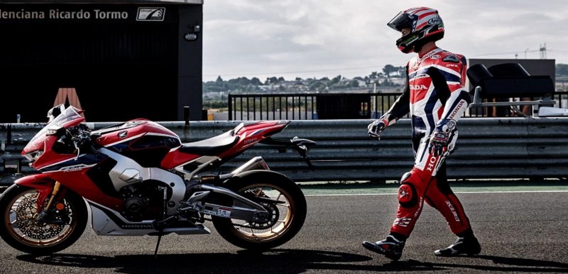a man walking to his custom 2019 Honda® CBR1000RR motorcycle